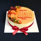 Round mousse cake with fresh fruit, a calendar design, and red ribbon.