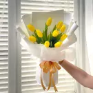 Bouquet of 10 yellow tulips wrapped in white paper, tied with a golden ribbon.