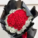 Bouquet of 101 red roses and baby's breath, wrapped in black paper.