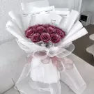 Amethyst Pink bouquet with glittery purple roses wrapped in white and pink mesh with ribbon.