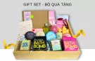 Gift set with bath bombs, rubber ducks, and a handwritten note in a wooden box.