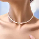 Woman wearing a high-quality pearl necklace and pearl stud earrings.