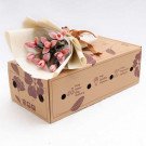 Pink tulips in a bouquet on a floral-printed box.