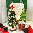 Cozy Christmas gift set with mini tree, mug, pinecones, and gift bag.