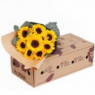 Bouquet of sunflowers in brown paper on a cardboard box with delivery information.