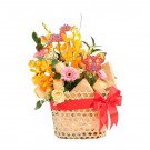 Basket of yellow orchids, peach roses, pink gerberas, and decorative dragon and butterfly.