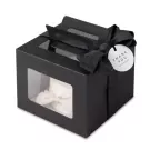 Black gift box with windows, tied with a black ribbon and a "Thank You" tag, revealing a white cake with a bow inside.