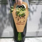 Person holding brown paper cone with daisies and "Wishing you a GREAT DAY!"