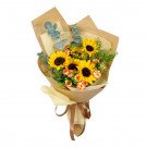 Bouquet of sunflowers, carnations, and greenery wrapped in brown paper with a ribbon.