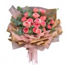 Bouquet of pink Ohara roses with eucalyptus, wrapped in brown newspaper and pink sheer paper.