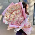 Money bouquet with Vietnamese dong bills and pink baby's breath flowers, held by a woman.