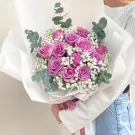 Bouquet of purple roses, baby's breath, and eucalyptus.