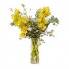 Yellow cymbidium orchids with eucalyptus and small white flowers in a clear vase.