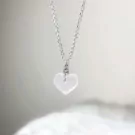 Silver necklace with a raw, clear quartz heart pendant.