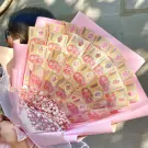 Money bouquet of Vietnamese 200,000 đồng banknotes with pink flowers and wrapping.