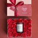 Gift box with red roses and a "Berry Bliss" candle, tied with a red ribbon.