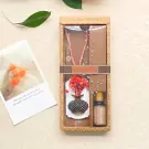 Gift set with a pink dreamcatcher, a flower-shaped diffuser, and essential oil.