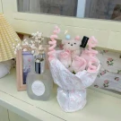 A bouquet with pink roses and a teddy bear.
