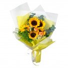 A bouquet of sunflowers, orange carnations, and other greenery wrapped in yellow and white paper.