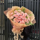Bouquet of 25 pink Shimmer roses, wrapped in textured paper and tied with a sheer ribbon bow.