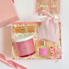 Pink gift box with candle, diffuser, cinnamon sticks, pink bag, and Women's Day card.