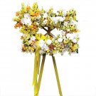 Square flower arrangement with yellow and white flowers and a yellow ribbon.