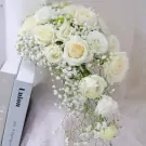 Cascading bridal bouquet with white roses and baby's breath.