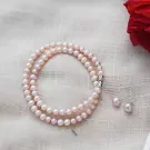 Double strand pink pearl necklace with a silver clasp and matching pearl stud earrings.