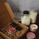 Gift box with candles, jars, and chocolate.