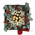 Ferrero Rocher chocolates arranged in a nest with baby's breath, eucalyptus, and berries.