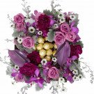 Box of purple flowers and chocolates.