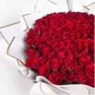 A large bouquet of 200 vibrant red roses wrapped in white and gold paper.