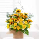 Sunflower and yellow rose bouquet in a burlap-wrapped cylinder container.