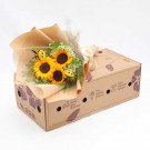 Sunflower and daisy bouquet with bee decorations in a cardboard box.