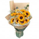Bouquet of sunflowers, baby's breath, and eucalyptus in kraft paper and green wrap.