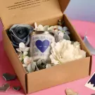 Love Spell Scented Candle gift set with flowers and hearts in a brown box.