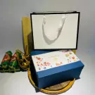 A gift box with candles, greeting cards, and decorative items.