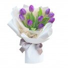 Bouquet of 10 purple tulips with white and tan paper wrap, tied with a grey ribbon.