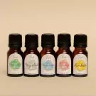 Five small amber glass bottles of essential oils with colorful labels.