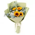 Bouquet of sunflowers and baby's breath in pale green paper wrap with white ribbon.