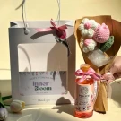 Gift set with a white bag, cherry blossom shower gel, and crochet tulip bouquet.