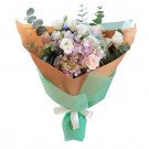 Pastel flower bouquet with roses, lisianthus, hydrangeas, and eucalyptus in brown and green paper wrap.