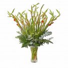 A vase of red gladiolus and white flowers with ferns and eucalyptus.