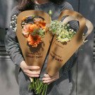 Two bouquets of flowers in brown paper wrappers held by a person in a striped shirt.