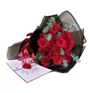 Red roses bouquet with a 3D pop-up heart card, tied with a red ribbon and wrapped in black paper.