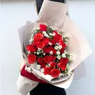 Bouquet of red roses with white filler flowers, wrapped in beige paper and tied with a cream ribbon.