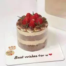 Tiramisu cake topped with fresh strawberries and dusted with cocoa powder.