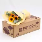 Bouquet of sunflowers with eucalyptus leaves, gift-wrapped in yellow paper, on top of a cardboard box.