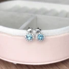 Silver stud earrings with blue topaz and diamond accents, shaped like stars.