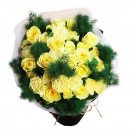 Yellow roses and carnations with green foliage in a bouquet.